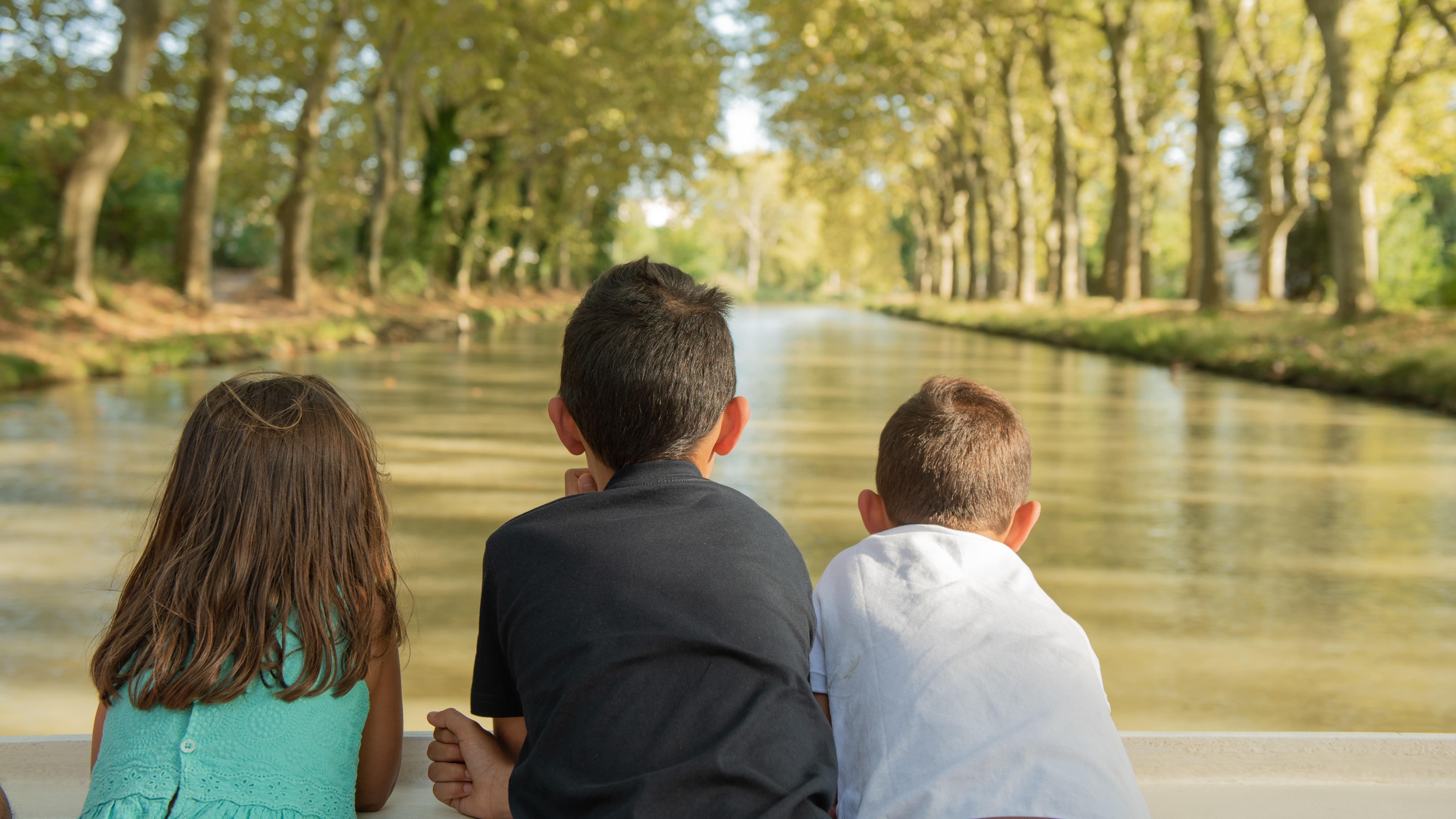 Enfants à l’arrière d’un bateau sur le canal du Midi