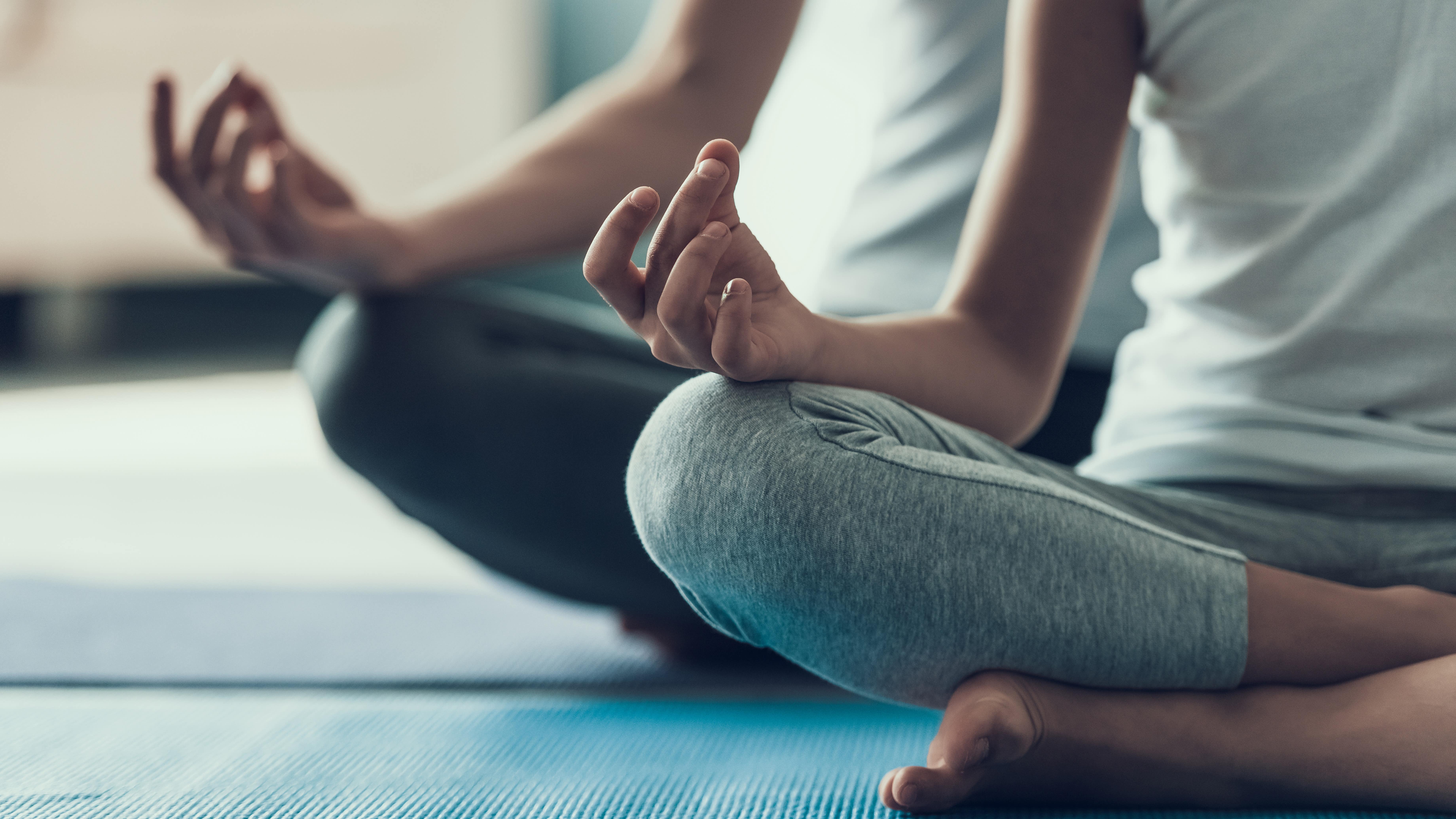 Un adulte et un enfant qui font du yoga
