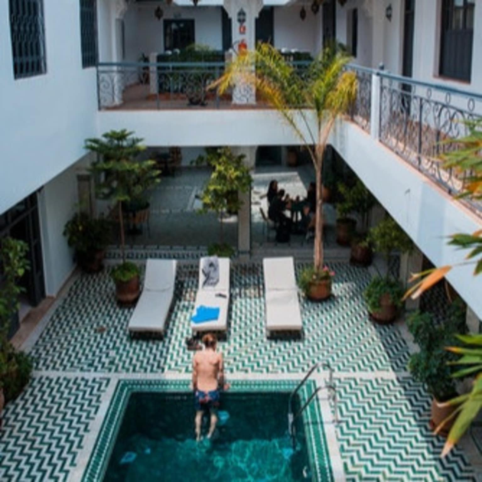 Riad avec piscine, plantes vertes, chaises longues, villa Marrakech